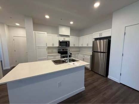A kitchen with white countertops and stainless steel appliances.