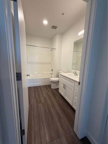 A bathroom with a toilet, sink, and bathtub.