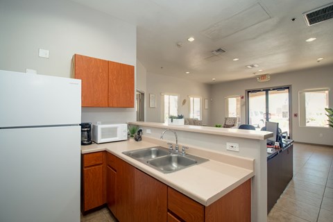 A kitchen with a white refrigerator and wooden cabinets.
