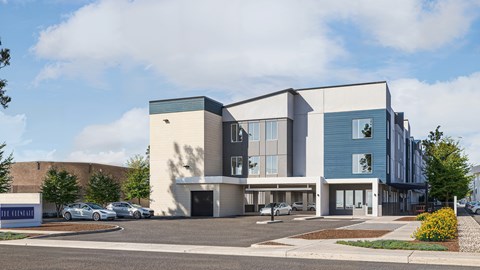 A modern building with a parking lot in front.