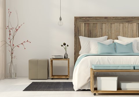 A bedroom with a large bed and a wooden headboard.