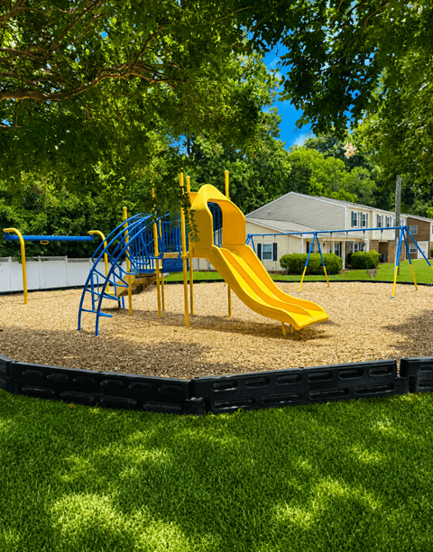 A playground with a yellow slide and blue play structure.
