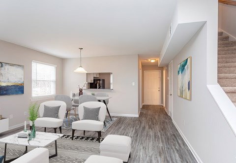 A living room with a grey carpet and white furniture.