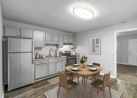 A kitchen with a table and chairs in front of it.