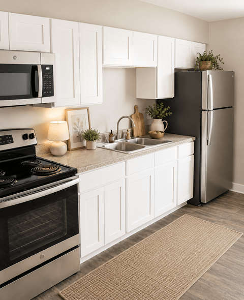 A modern kitchen with white cabinets and stainless steel appliances.