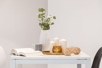 a white desk with a vase and candles on it at Capital Flats & Magnolia Square Apartments, Raleigh, NC, 27601