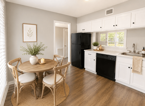 A kitchen with a round table and chairs, a black refrigerator, and a window with blinds.