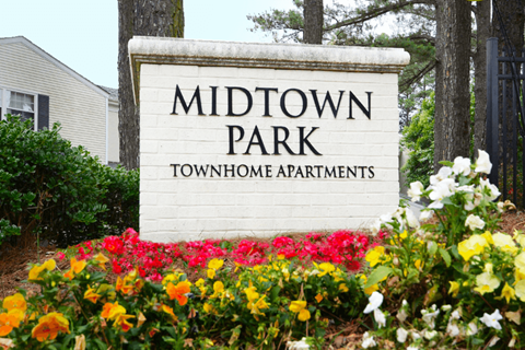 a sign formidtown park in front of flowers