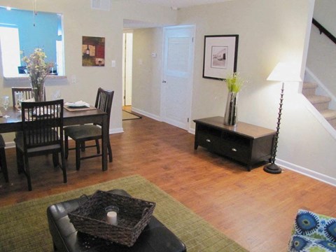 a living room and dining room with a table and chairs