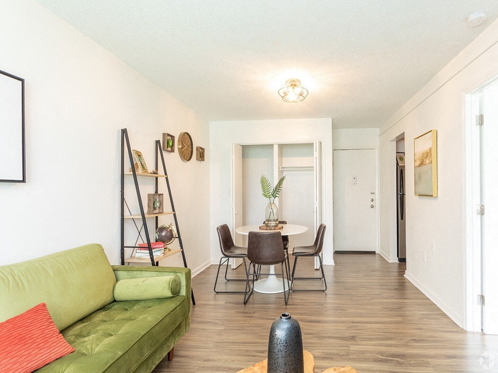 a living room with a green couch and a dining room table