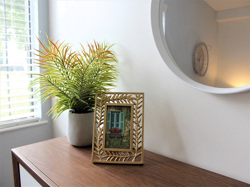 a picture frame sitting on a table with a plant