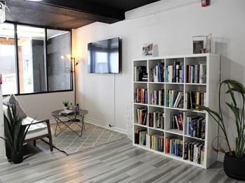 a living room with a bookshelf full of books at Capital Flats & Magnolia Square Apartments, Raleigh, NC, 27601