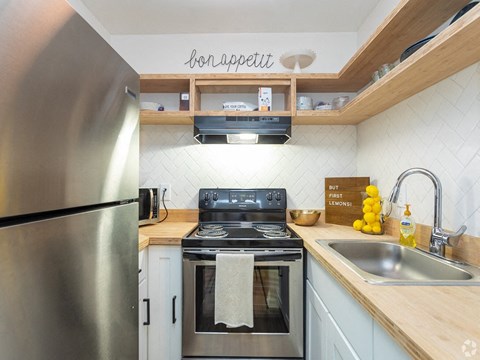 a kitchen with stainless steel appliances and wooden counter tops