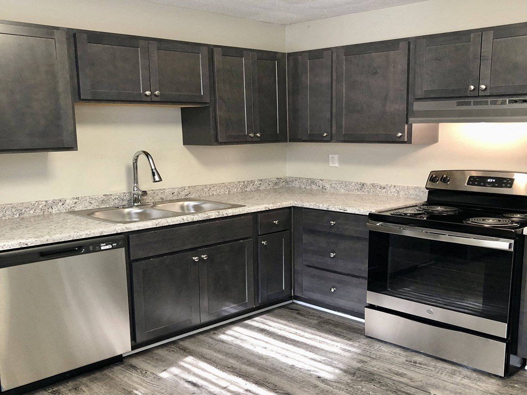 a kitchen with black cabinets and stainless steel appliances