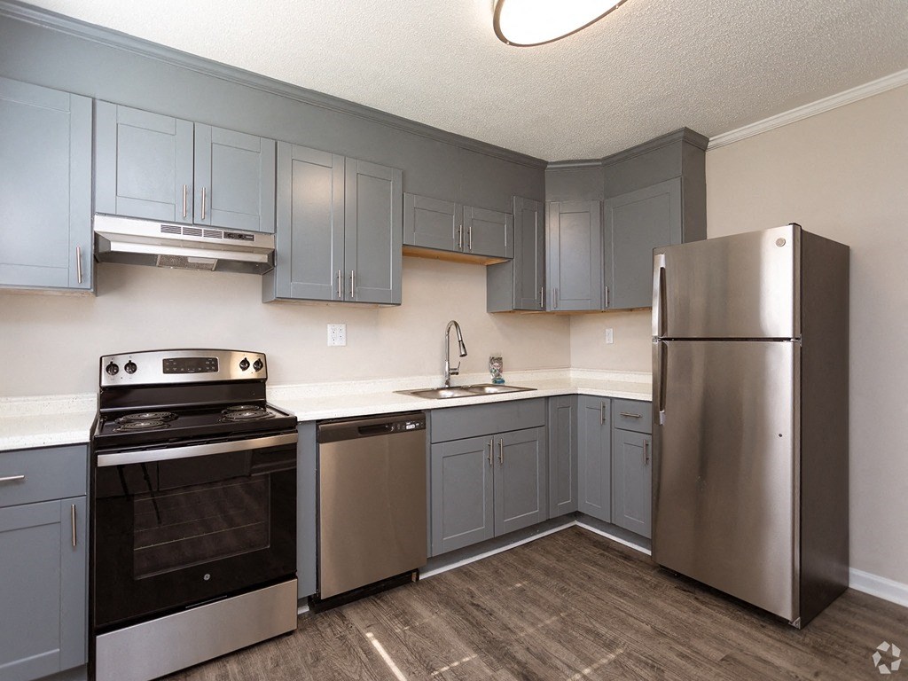 an empty kitchen with stainless steel appliances and blue cabinets