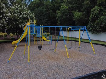 a swing set at a playground in a park at Colony Townhomes, Raleigh, 27609