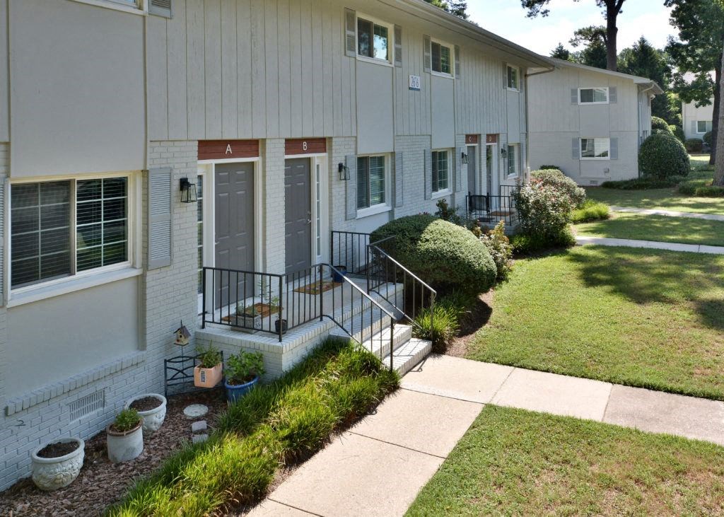 a white house with a sidewalk in front of it