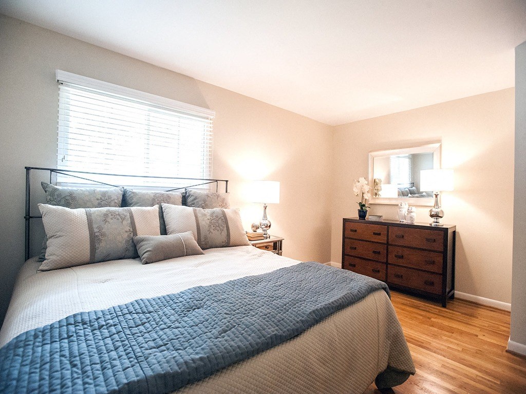 a bedroom with a bed and a dresser and a window