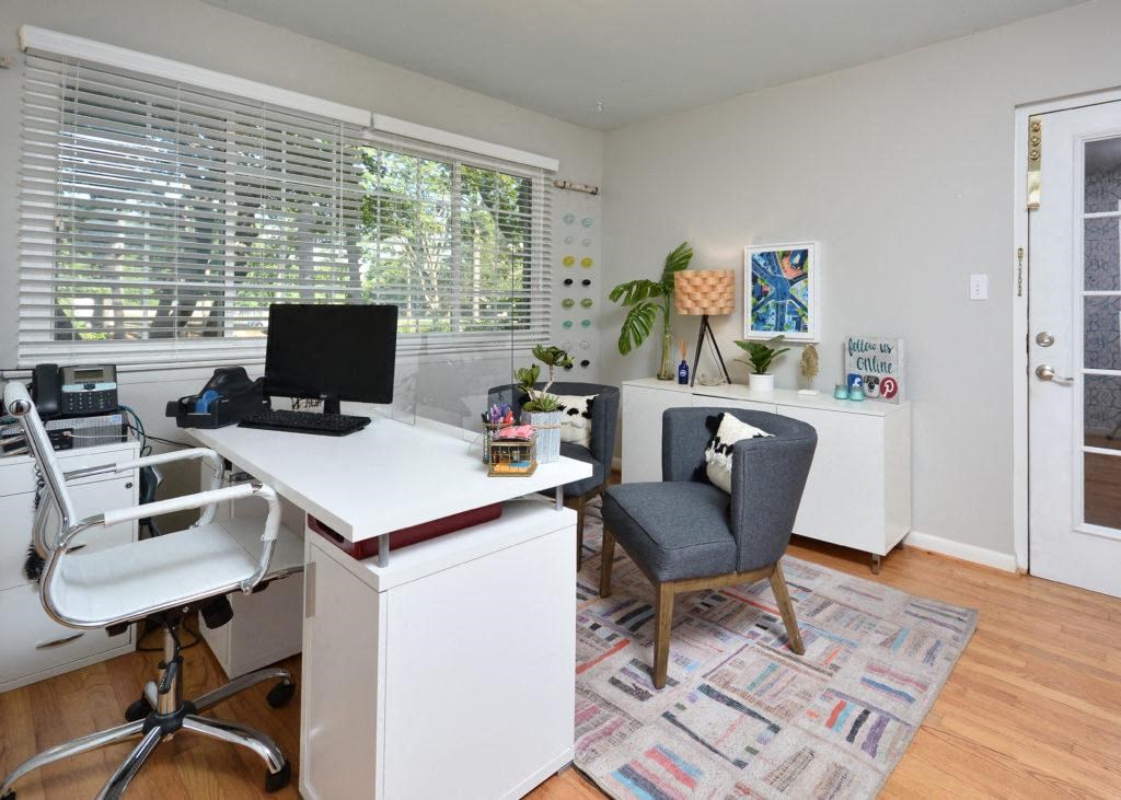 a home office with a large window and a desk with a computer
