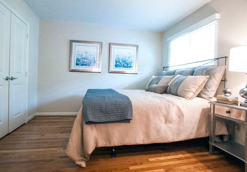 a bedroom with a bed and two pictures on the wall