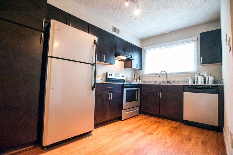 a kitchen with stainless steel appliances and a wood floor