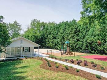 a yard with a playground and a house