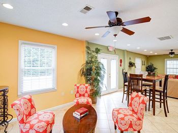 a living room with a table and chairs and a ceiling fan
