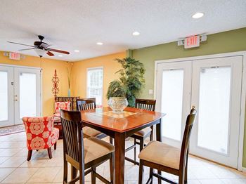 a dining room with a table and chairs and a ceiling fan