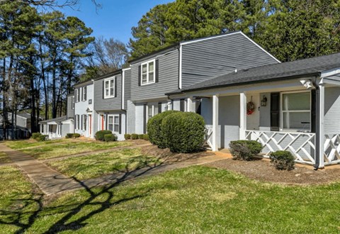 a white and gray house with a sidewalk in front of it