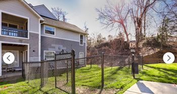 the back yard of a house with a fenced yard and a chain link fence