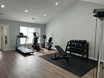 a home gym with exercise equipment and a window