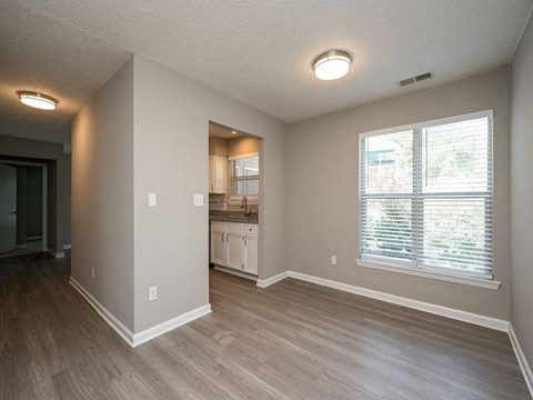an empty living room and kitchen with a large window