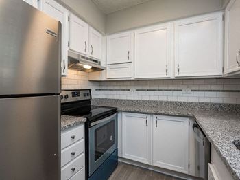 a kitchen with stainless steel appliances and white cabinets