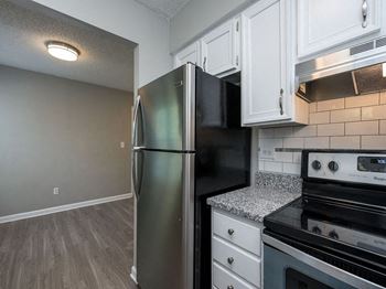 a kitchen with stainless steel appliances and white cabinets