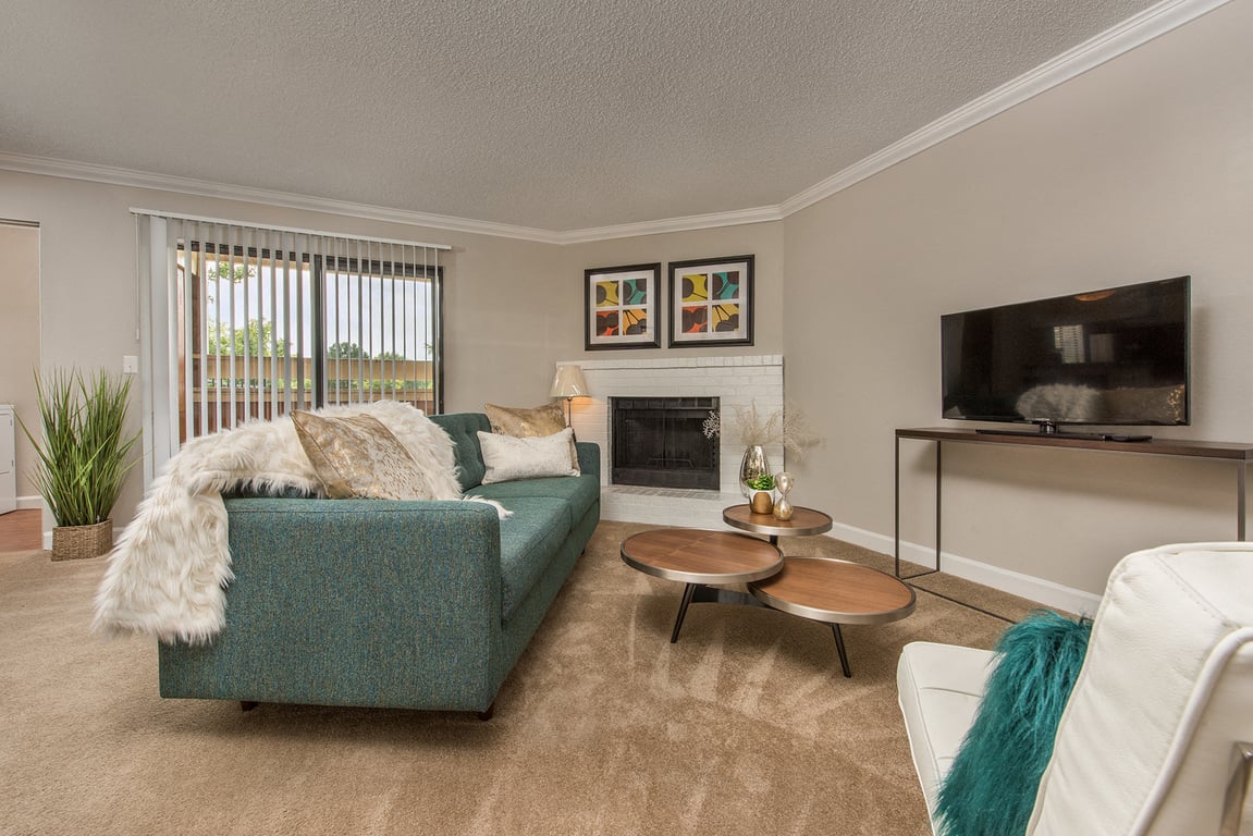 a living room with a blue couch and a fireplace