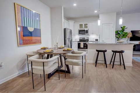 A kitchen with a dining table and chairs.