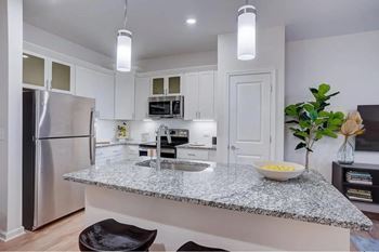 A kitchen with granite countertops and stainless steel appliances.