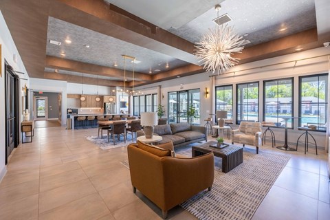 A large, modern living room with a high ceiling and a mix of furniture types.