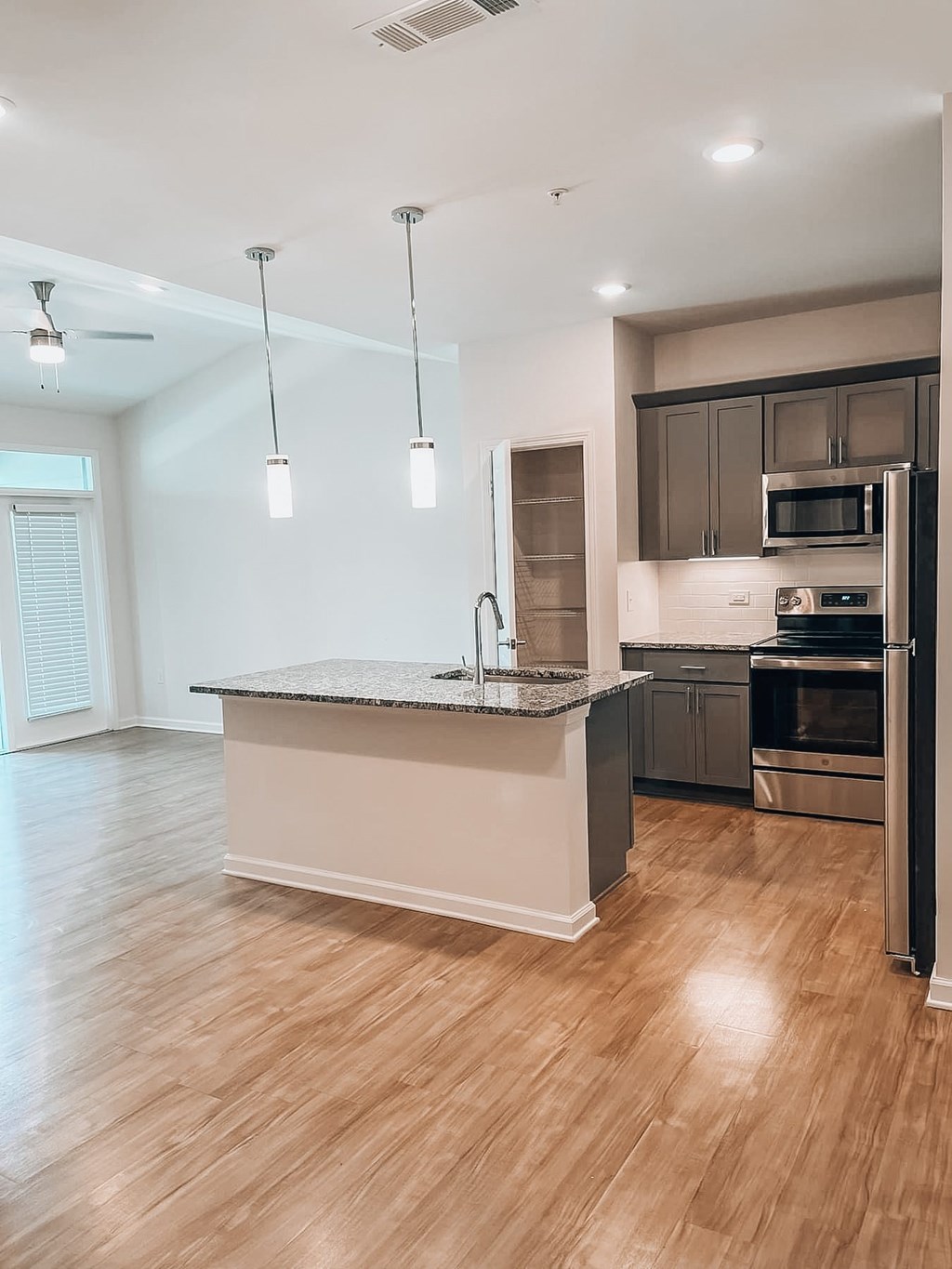 A modern kitchen with a granite countertop and stainless steel appliances.at Evolve at Parkway Apartment Homes, Concord