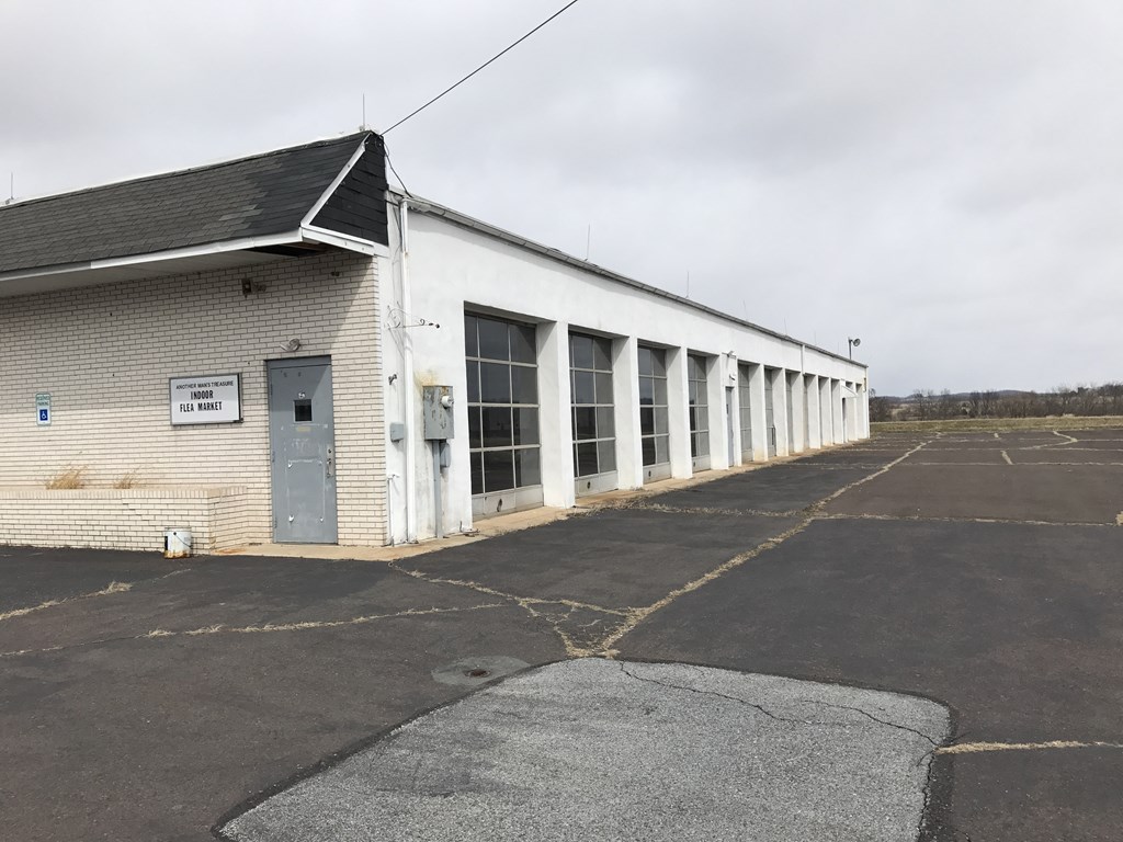 the side of a white building with windows and a parking lot