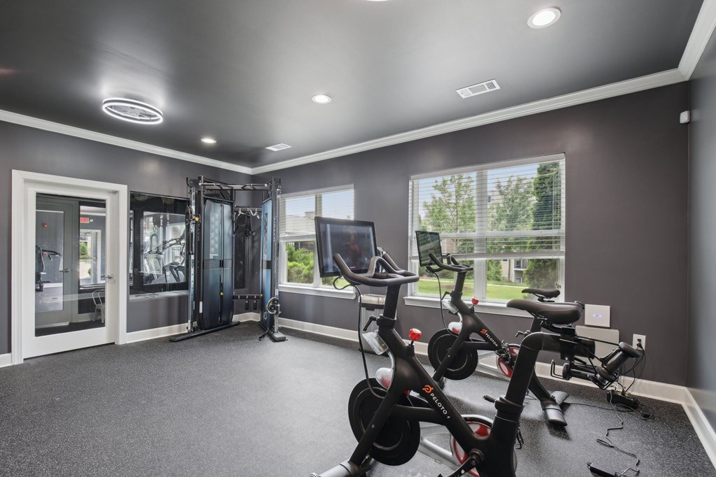 A spacious home gym with a row of stationary bikes and a treadmill at Venue at 109 Apartments, Lebanon 