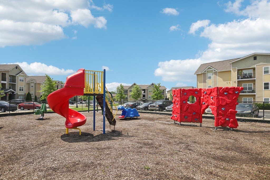 A playground with a red slide and a red climbing structure at Venue at 109 Apartments, Tennessee