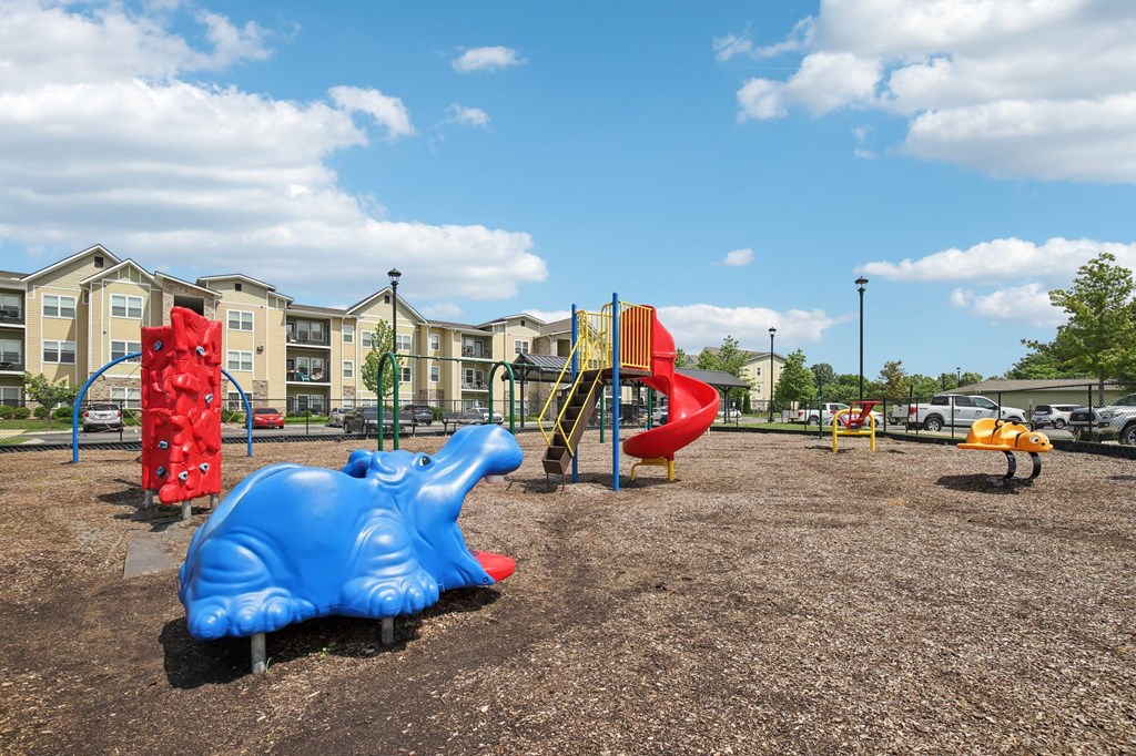 A blue hippo playground slide in a playground with apartment buildings in the background at Venue at 109 Apartments, Lebanon 