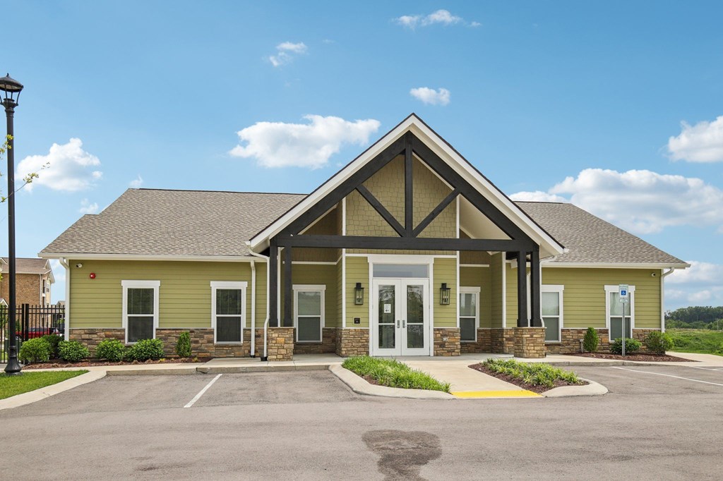 A small building with a yellow and green exterior and a black metal fence in front at Venue at 109 Apartments, Lebanon 
