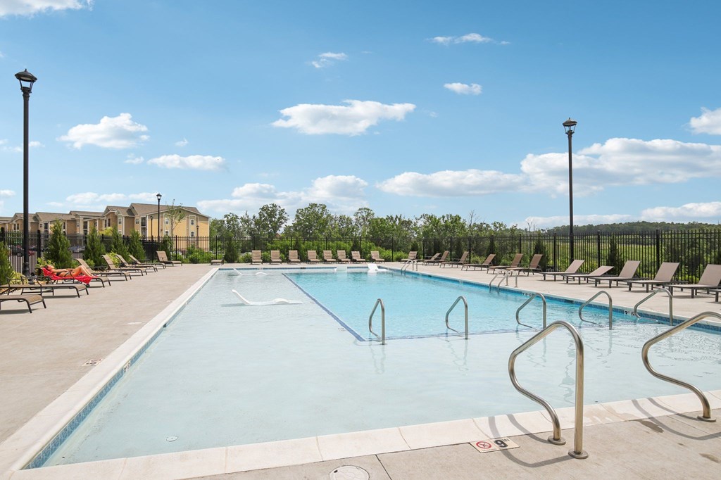 A large outdoor swimming pool with a metal ladder on the side at Venue at 109 Apartments, Lebanon  37090