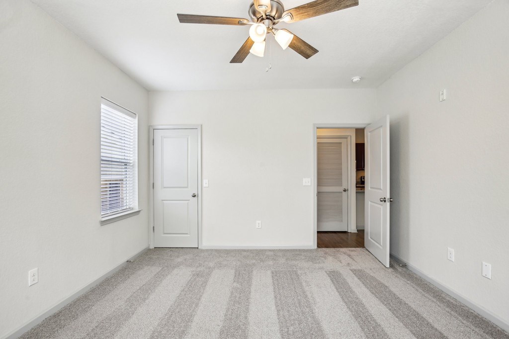 A room with a ceiling fan and striped carpet at Venue at 109 Apartments, Lebanon , TN