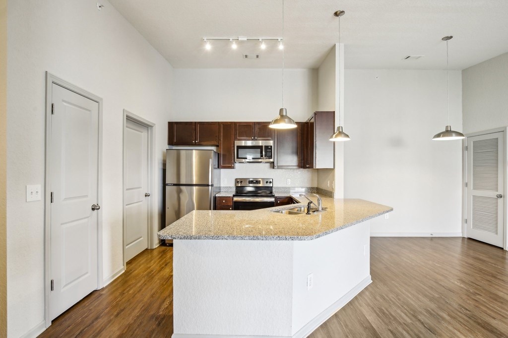 A kitchen with a white island and wooden floors at Venue at 109 Apartments, Lebanon  37090