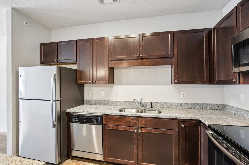 A kitchen with brown cabinets and a stainless steel refrigerator at Venue at 109 Apartments, Lebanon , TN