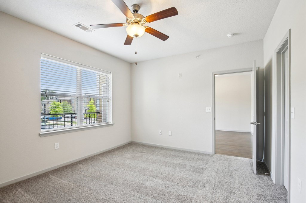 A room with a ceiling fan and a window overlooking a patio at Venue at 109 Apartments, Lebanon , Tennessee