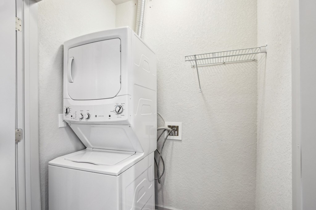 A white washing machine and dryer in a small laundry room at Venue at 109 Apartments, Tennessee, 37090